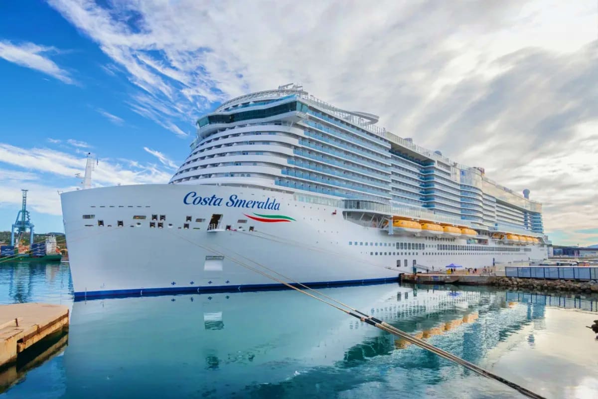 Costa Smeralda cruise ship docked at port with white hull and multiple passenger decks under partly cloudy sky